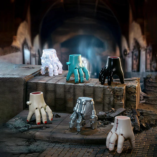 Set of ceramic feet sculptures in various colors on a rustic stone surface with a smoky background.